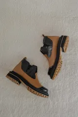 Botas Chelsea color marrón con paneles laterales elásticos y suela track.