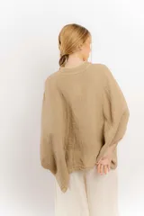 Camisa celeste de lino con corte amplio, cuello mao y mangas cortas. Presenta cierre frontal con botones y ribete negro en cuello y tapeta.