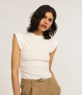 Blusa color crema con cuello redondo y mangas cortas. Presenta un recorte texturizado en el busto y está confeccionada en algodón.