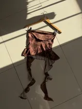 Top strapless de tela transparente con estampado animal print en tonos marrones. Presenta un ruedo con volados y un calce ajustado en el busto.