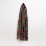 Pashmina estampada con motivos florales en tonos naranja, azul y marrón.