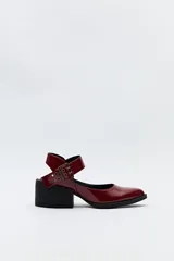 Zapato de charol color borgoña con correa al tobillo con hebilla metálica y taco cuadrado bajo color negro.