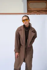 Tapado marrón de lana, corte oversize, con cuello solapa, cierre con botones y cinturón.