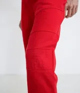 Pantalón jogger rojo de algodón con ajuste en los tobillos, bolsillos laterales con cierre y cintura elástica.
