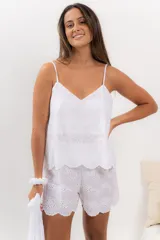 Pijama de algodón blanco con bordado calado, compuesto por musculosa con escote en V y short con cintura elástica y volados.