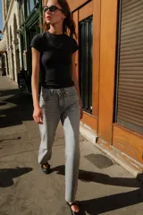 Pantalón de jean gris de corte recto, tiro alto y largo hasta el tobillo.