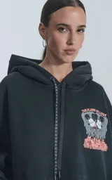 Buzo con capucha negro de frisa de algodón con calce oversize. Estampado en el frente con diseño de Mickey y Minnie Mouse con la leyenda "The Flame of Love".