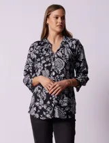 Blusa negra con estampado floral blanco, cuello mao con escote en V y abertura frontal con botones. Manga 3/4 con terminación fruncida.