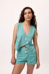 Chaleco marrón con escote en V y cierre cruzado con dos botones.