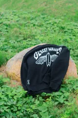 Buzo negro con estampado en la espalda que dice "Glossy Waves" con una tabla de surf.