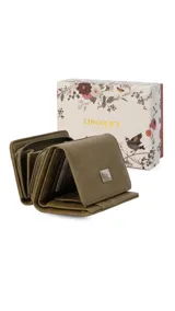 Billetera corta de símil cuero color beige claro, con cierre de broche a presión en la solapa principal. Presenta múltiples compartimentos internos para tarjetas y billetes, y un bolsillo exterior con cierre en la parte posterior. Lleva una placa metálica con el logo de la marca.