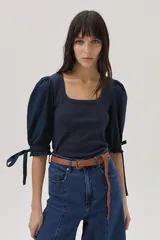 Top azul de tejido de punto con cuello cuadrado y mangas abullonadas con lazos.