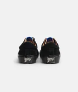 Zapatillas bajas de gamuza negra con suela y cordones negros.