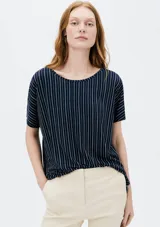 Blusa azul marino con rayas verticales blancas, de corte holgado y mangas cortas.