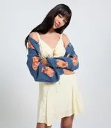 Vestido corto de corte evasé en color amarillo claro con estampado de cuadros. Posee escote en V, detalle de lazo central, fruncido bajo el busto y breteles finos regulables. Confeccionado en tejido de viscosa con forro de poliéster.