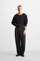 Sweater negro de punto con estructura de canalé, corte relaxed fit, cuello redondo y cierre de botones en el hombro.