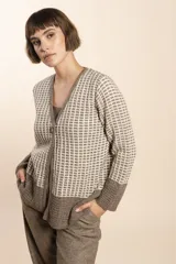 Cardigan tejido con efecto fantasia color crema. Una prenda de silueta amplia y cómoda. Tejido en 100% lana fina sin teñir.