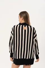 Saco oversize tejido a rayas verticales en blanco y negro, con escote en V y botones.