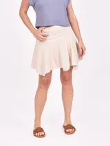 Minifalda de tejido texturizado color crudo, con cintura elastizada y ruedo desflecado.
