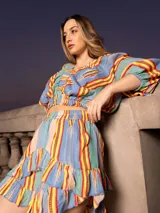 Conjunto de short y top con estampado a rayas verticales de colores azul, verde, amarillo y rojo. El short es de tiro alto con volados en el ruedo y el top es cropped con escote en V y mangas cortas abullonadas.