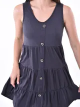 Vestido corto gris oscuro, sin mangas, con escote en V y botones frontales. Tiene corte imperio y falda con volantes.
