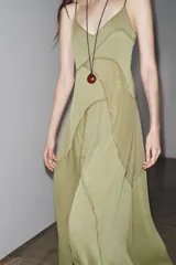 Vestido largo color verde oliva, de escote pico y tirantes finos ajustables. Confeccionado en tejido fluido combinado a tono y forro interior.