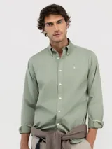 Camisa verde de hombre confeccionada en 100% algodón, tintada en prenda envejecida para darle un acabado vintage. Corte Regular Fit, cuello buttondown y cierre con botones. Manga larga terminada en puño simple y logo en el pecho bordado