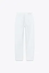 Pantalón de jean gris oscuro, de corte mom fit, tiro alto y largo tobillero. Cuenta con cinco bolsillos, cierre frontal con cremallera y botón.