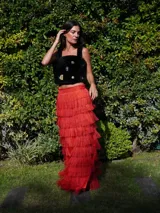 Falda larga color rojo con flecos en capas y cintura alta.