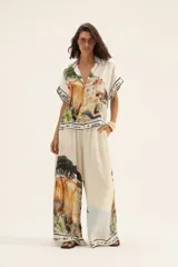 Pantalón palazzo de seda color crema con estampado de paisaje.