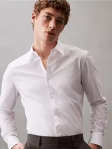 Camisa blanca de algodón, poliéster y elastano, de corte slim, manga larga y cuello en punta.