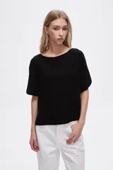Blusa negra de viscosa, corte holgado y cuello redondo.