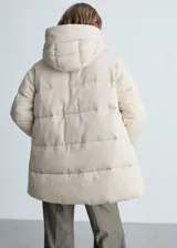 Campera puffer color beige con capucha, cierre frontal con cremallera y bolsillos laterales.