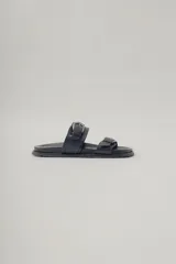 Sandalias negras de cuero sintético con doble tira y hebillas metálicas.