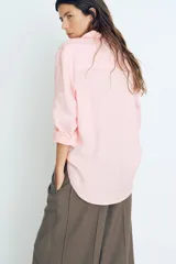 Camisa rosa de lino liviano, de corte recto, con cuello clásico, botones frontales, manga larga con puños abotonados, canesú en la espalda, bolsillo de parche en el pecho y bajo redondeado.
