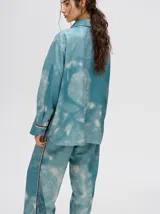 Camisa oversize celeste con estampado tie-dye, bolsillo en el pecho con bordado y terminaciones con ribete en contraste.