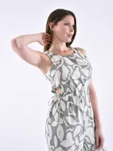 Monoprenda sin mangas con estampado orgánico en color verde y beige. Presenta un diseño con cuello redondo, aberturas laterales en la cintura con cordones ajustables y pantalones de pierna ancha.