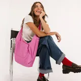 Bolso tipo hobo, color rosado, con correa de hombro y bolsillo frontal.