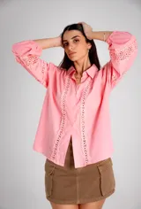 Camisa rosa con detalles de broderie en el frente y mangas globo.