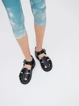 Sandalias romanas color verde oliva, con tiras entrecruzadas y hebilla lateral. Suela de goma negra con plataforma de 3cm. Fabricadas en cuero vacuno.