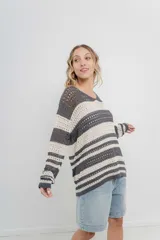 Sweater tejido calado a rayas horizontales anchas en color gris oscuro y crudo, con escote en V y corte recto.