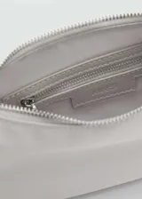 Bolso tipo baguette color gris claro, con correa corta al hombro y cierre superior.
