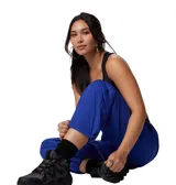 Pantalón negro de mujer, de corte recto y tiro alto, con cintura elástica ajustable con cordón, bolsillos laterales y bolsillo adicional en la pierna. Cuenta con puños ajustables con cordón y forro de malla para mayor transpirabilidad.