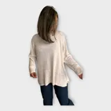 Sweater tejido color crudo, con escote redondo y hebra en relieve con brillo.