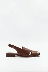 Sandalias destalonadas de cuero marrón con diseño entretejido en la parte delantera y hebilla lateral.
