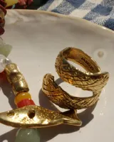 Anillo dorado con diseño de serpiente enroscada.
