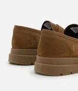 Mocasín masculino de gamuza color marrón con suela track dentada y puntera redonda. Posee el detalle clásico de antifaz sobre el empeine y costuras visibles al tono.