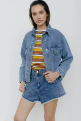 Campera de jean celeste con bolsillos frontales y botones metálicos.