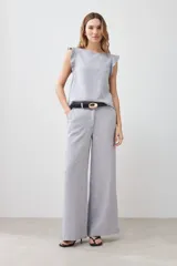 Blusa gris melange sin mangas con volados en los hombros y vivo metálico.