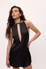 Minivestido negro de satén con escote halter y espalda descubierta.